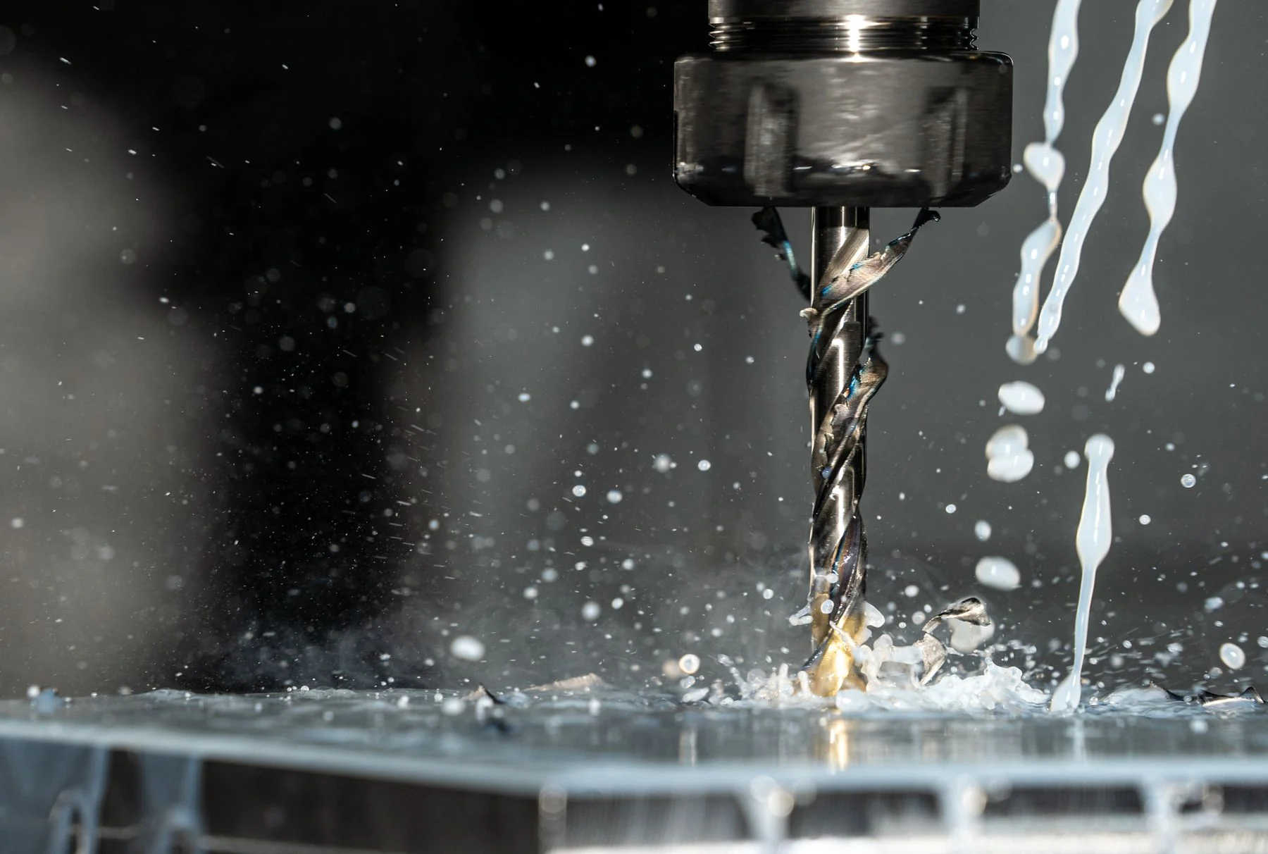 CNC cutting tool machining metal with a stream of metalworking fluid