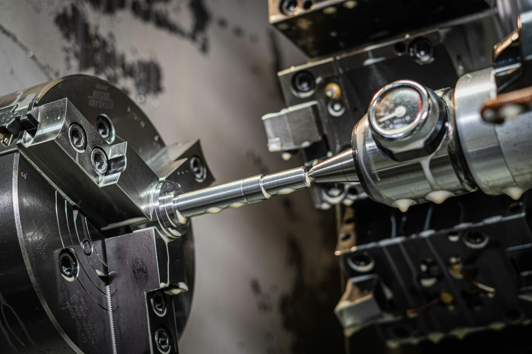 Lathe chuck, cylindrical workpiece and turning tools inside a CNC machine