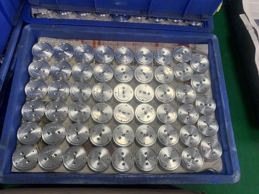 Grouped machined components arranged in protective production trays
